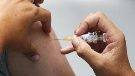 Un sanitario administra la vacuna de la gripe a una persona. DN
