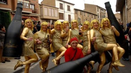 Un grupo de vecinas de Tafalla disfrazadas de las populares burbujas de Freixenet, junto al niño vestido de rojo que siempre las acompaña en los anuncios con la botella bajo el brazo, ayer durante el desfile del carnaval de Tafalla. ALBERTO GALDONA