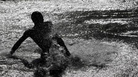 Niños y mayores se bañan en el río Arga a su paso por Pamplona.