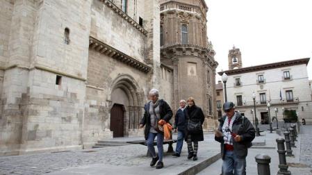 Varios turistas pasean por la plaza Vieja de Tudela, junto a la fachada norte de la catedral.