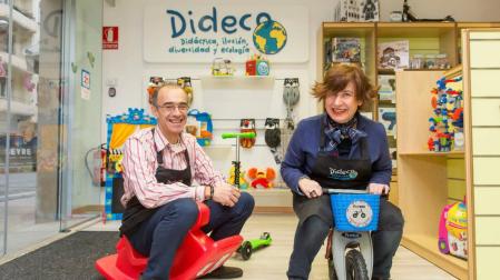 Javier Lacasia, un un balancín, y Cristina Fernández, en una bicicleta, en la tienda Dideco, que han abierto en el Ensanche.