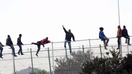Decenas de inmigrantes se encaraman a la valla de Melilla