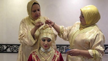 Dos mujeres preparan a una novia con Hiyab.