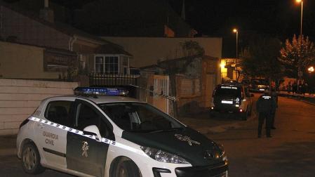 Un coche de la Guardia Civil junto a la vienda donde los cadáveres de un hombre y una mujer han sido hallados