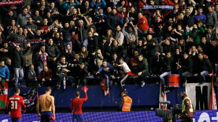 Aficionados de Osasuna piden la camiseta a los jugadores tras el partido contra el Atlético.
