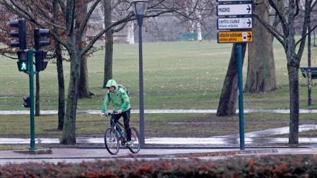 Un ciclista atraviesa la avenida Pío XII a la altura de la Vuelta del Castillo, bajo la lluvia.