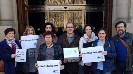 Una representación de los afectados posa en la puerta del Parlamento después de reunirse con su presidenta.