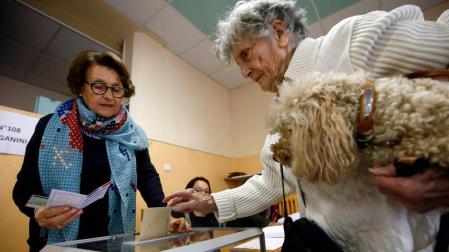 Una mujer mete la papeleta en una urna en la segunda vuelta de las elecciones presidenciales de Francia.