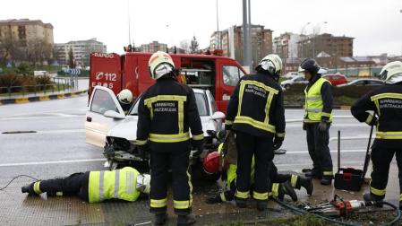 Bomberos actúan con un vehículo implicado en un siniestro en Pamplona.