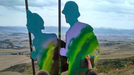 Voluntarios limpian los grafitis del Monumento al Peregrino en El Perdón