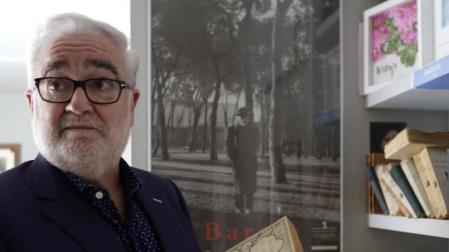 Joaquín Ciáurriz ojea las primeras ediciones de libros de Baroja de su colección. Detrás, la célebre foto del novelista paseando por el Retiro.