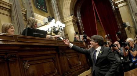 El presidente de la Generaliatat, Carles Puigdemont (d) junto a la presidenta de la cámara catalana, Carme Forcadell (i) vota en el pleno del Parlament.