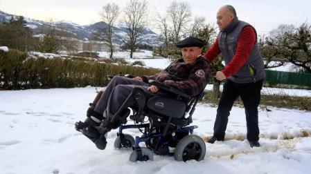 Empujando por la nieve su silla de ruedas, Elard Vargas acompaña a Tomás Belzunegui.