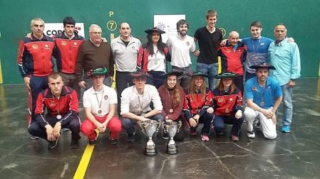 Miguel Pozueta, junto con los pelotaris y técnicos de la Federación Navarra de Pelota ayer en el frontón Ogueta de Vitoria, con los trofeos.