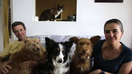 Antón Iraizoz Apezteguía y Ester Lutteroth Elizondo con Noa, Tukla y Kuka en el sofá de su casa de Ansoáin. Arriba, Katu.