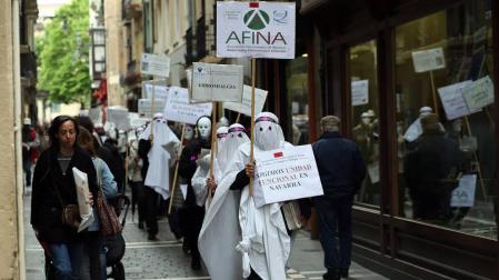 Miembros encapuchados de la Asociación de Fibromialgia recorrieron las calles de casco viejo de Pamplona.