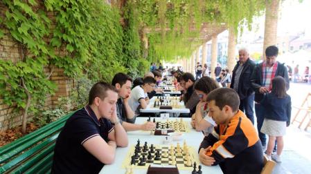 Los inscritos en el torneo de ajedrez juegan sus partidas en el paseo del Queiles.