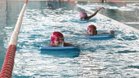 Niños del colegio Compañía de María nada en la piscina cubierta municipal de Tudela durante su clase de Educación Física
