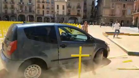 Un coche arrolla cruces amarillas por los presos en la plaza de Vic