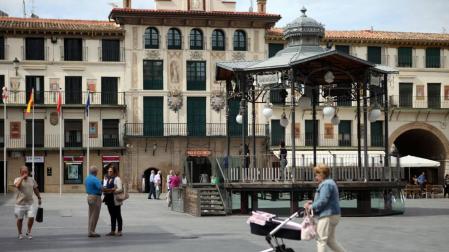 Varias personas pasean junto al quiosco de la plaza de los Fueros, centro neurálgico de Tudela.
