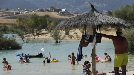 Varias personas se alivian del calor en el pantano de Alloz y en el río Arga a su paso por Irotz.