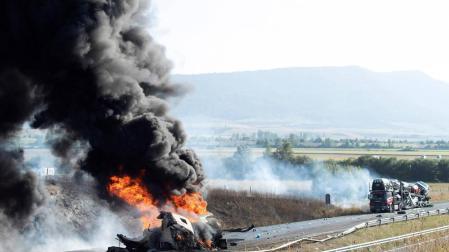 Vista del camión cisterna que se ha incendiado tras colisionar con otro camión que transporta vehículos en el kilómetro 380 de la A-1 a la altura del término municipio alavés de Agurain-Salvatierra.