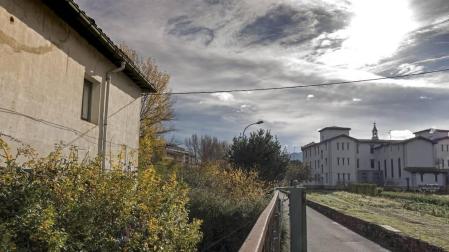 En primer término, la casa del administrador que se derribará para construir las diez viviendas. Se edificarán en hilera, a través del terreno de frutales y hacia la zona utilizada como aparcamiento por la residencia.
