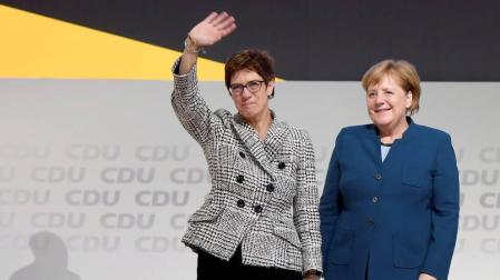 Annegret Kramp-Karrenbauer saluda junto a Angela Merkel