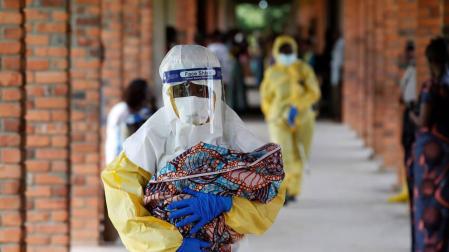 Un sanitario porta a un bebé sospechoso de estar infectado con ébola en el Congo.