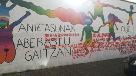 Pintadas contra Skolae sobre el mural de la diversidad en Huarte.