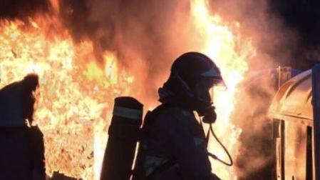 Efectivos de bomberos apagan un incendio en unos contenedores (imagen de recurso).