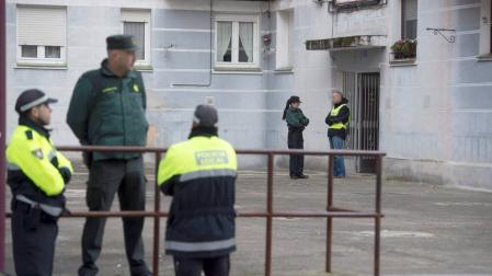 Agentes de la Guardia Civil en el portal del domicilio en el que una mujer de 26 años ha sido asesinada a puñaladas supuestamente por su novio en Laredo.