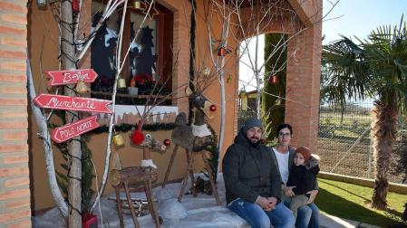 Rosa Jarauta, junto a su pareja Sergio Escribano y su hijo Noah, ante la decoración navideña de su casa.