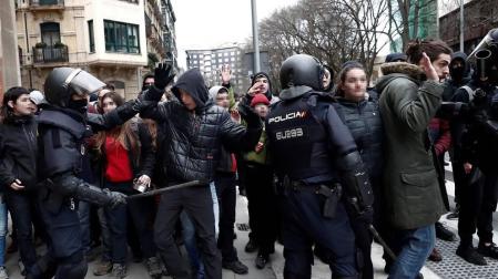 Efectivos de la Policía Nacional disuelven una concentración que han llevado a cabo un centenar de jóvenes junto al Parlamento de Navarra donde han acudido para protestar por la intervención de la Policía Foral esta madrugada en el palacio del Marqués de Rozalejo.
