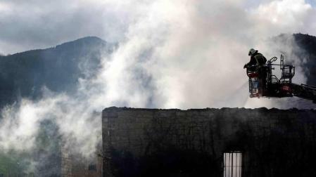Bomberos del Gobierno de Navarra y agentes de la Policía Foral trabajan en el incendio que esta madrugada ha calcinado una vivienda en la localidad de Artaiz (Unciti).