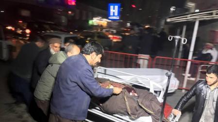 Varios hombres trasladan a un herido tras un atentado con coche bomba en Kabul (Afganistán).