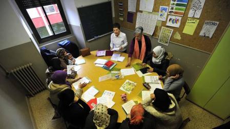 Dos voluntarias imparten clase a uno de los grupos más numerosos de las clases de alfabetización.