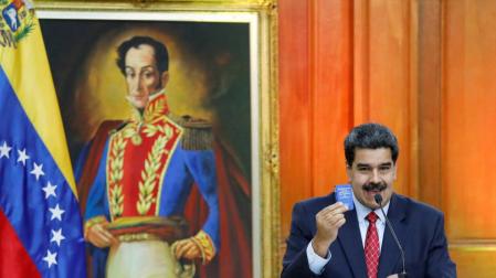 Nicolás Maduro sostiene un miniejemplar de la Constitución venezolana en una conferencia de prensa en el Palacio de Miraflores.