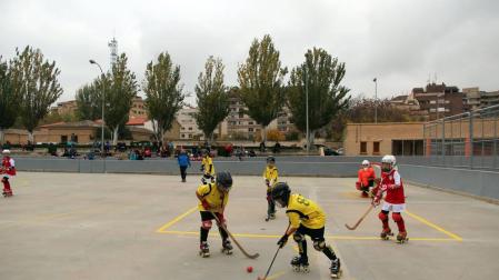 Imagen de un partido de las categorías inferiores del Tudela Hockey Club en la pista central del patinódromo.