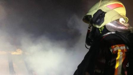 Un bombero apagando el incendio de una vivienda en Alsasua