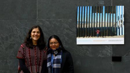 Andrea Villaseñor y Karla Rivas, con una fotografía del periodista Iván Benítez tomada en la valla de Tijuana y que se expone en el Parlamento de Navarra como parte de la muestra 'Stand by: más allá de las fronteras'.