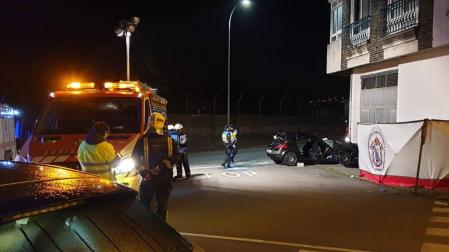 Bomberos junto al coche, en el lugar del accidente.