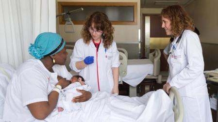 Fily Traore y su hija Niagale Fofana, atendidas por dos profesionales en su habitación del hospital.