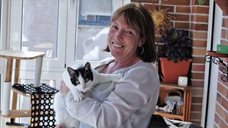 Pilar Nieto Jiménez sostiene entre los brazos a Forrest, el gato que hace cuatro meses llegó a sus vidas de casualidad.