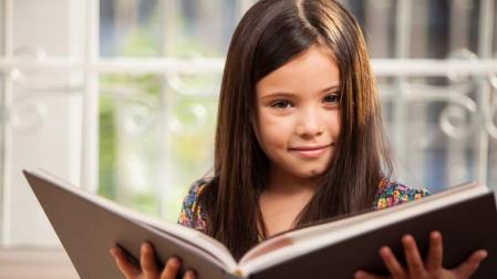 Una niña leyendo un libro.