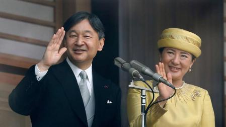 El emperador Naruhito y su esposa Masako saludan desde el Palacio Imperial de Tokio.