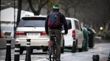 Un hombre en bicicleta, durante una jornada lluviosa en el Paseo Sarasate de Pamplona.