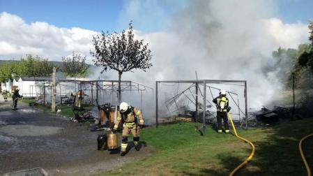 Varios bomberos trabajan en la extinción del fuego en el camping.