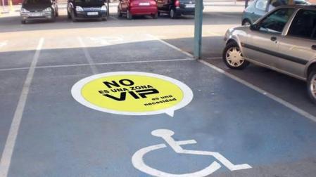 Vinilo sobre una plaza de aparcamiento para personas con discapacidad.