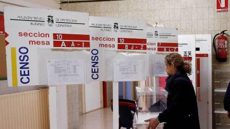 Trabajadores del Ayuntamiento de Pamplona durante la colocación de los paneles, urnas y papeletas en un colegio electoral de la capital navarra.